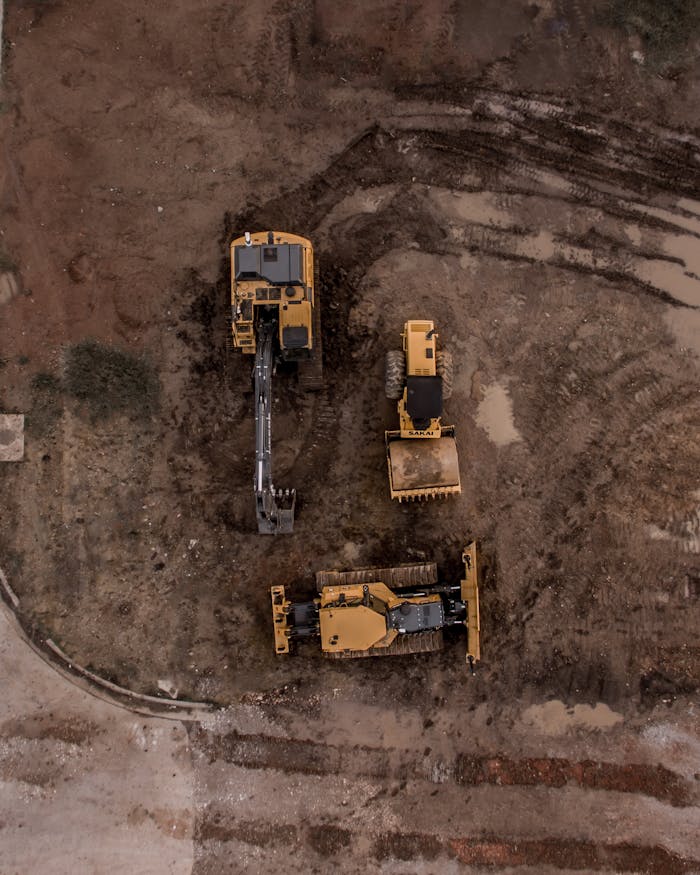 The Art of Drawing Readers In: Your attractive post title goes here An aerial shot of heavy machinery at a construction site, including excavators and road rollers.