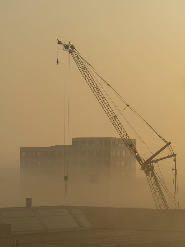 Crafting Captivating Headlines: Your awesome post title goes here Cranes silhouetted against a misty Copenhagen sunrise, capturing urban construction.